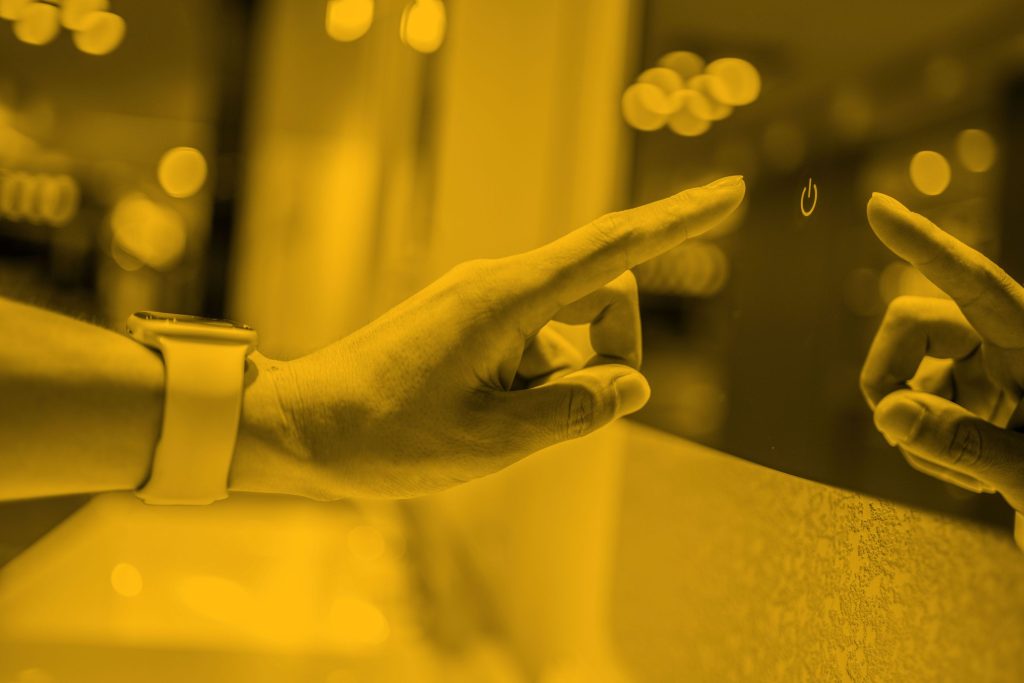 Woman reaching out index finger to press button on glass screen